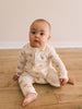 Baby sitting on wooden floor wearing cream pajamas with bear print Printed Long Sleeve One Piece - Cosy Bear Ecru Baby boy