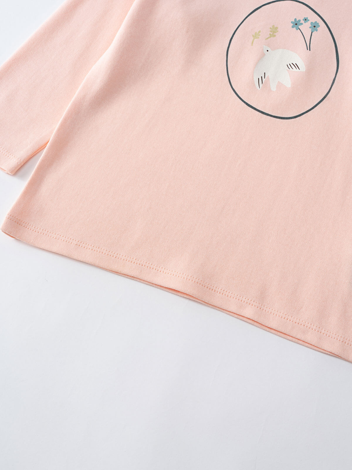 Close-up of pale pink long sleeve shirt with white bear and flower graphic Printed Long Sleeve Tee - Dove Girls
