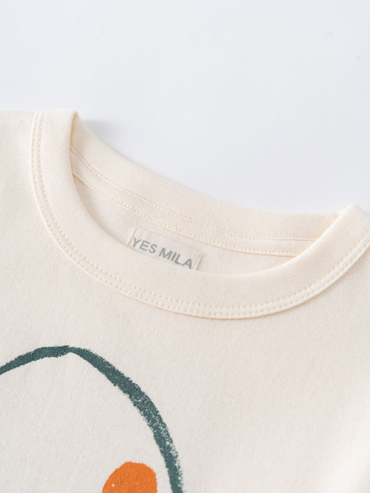 Close-up of cream-colored shirt collar with partial circular graphic design visible Printed Long Sleeve Tee - Stay Wild Boys