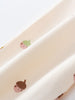 Close-up of cream fabric with small acorn face prints in brown and green Printed Sweatpants - Little Acorn Ecru Baby girl