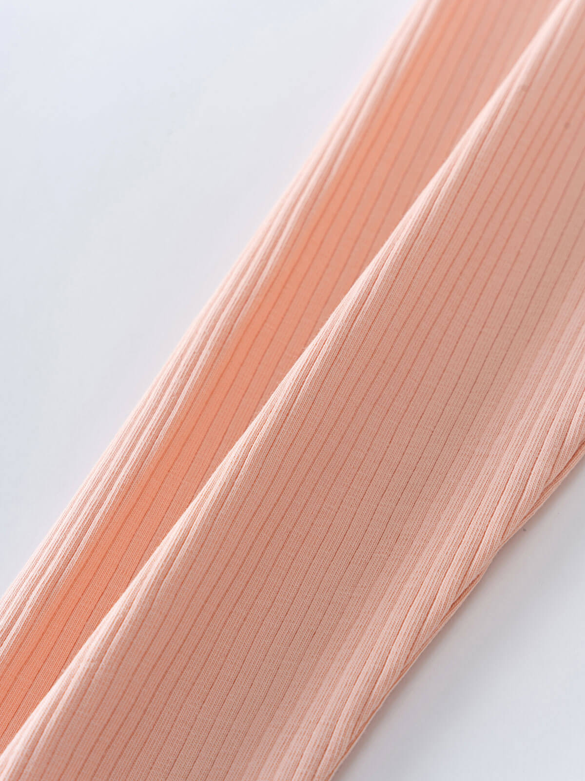 Close-up of ribbed peach-colored fabric showing texture and vertical lines Ribbed Leggings - Mallow Girls