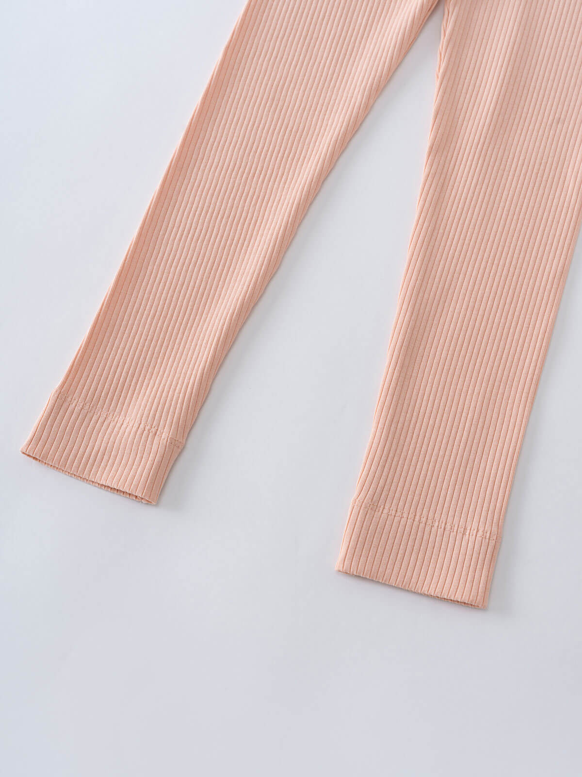 Close-up of ribbed peach-colored leggings on a light gray surface Ribbed Leggings - Mallow Girls