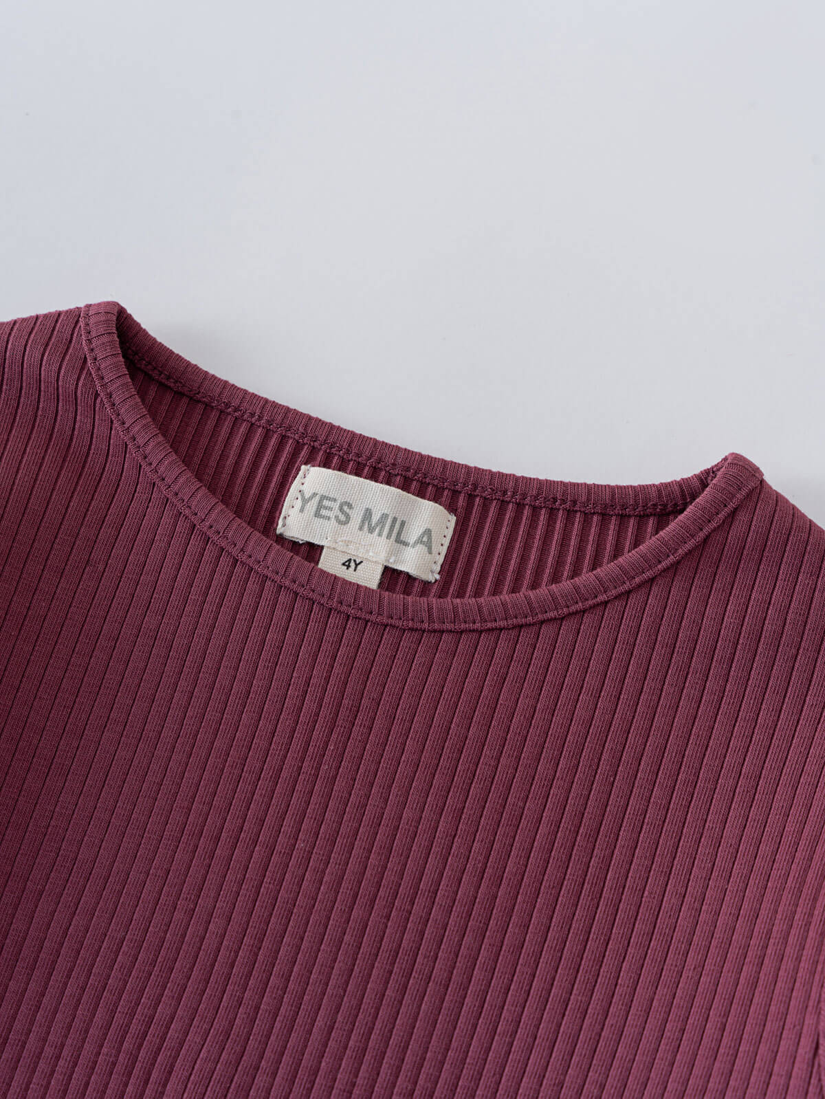Close-up of a plum-colored ribbed long sleeve shirt neckline with label Ribbed Long Sleeve Tee - Plum Jam Girls