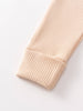 Close-up of ribbed knit fabric sleeve cuff in beige color Ribbed Long Sleeve One Piece - Clay Baby girl