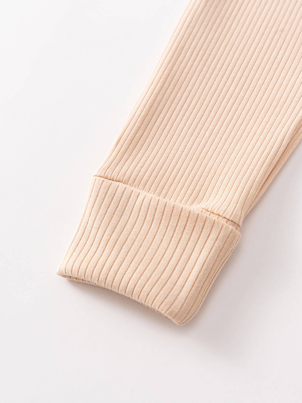 Close-up of ribbed knit fabric sleeve cuff in beige color Ribbed Long Sleeve One Piece - Clay Baby girl