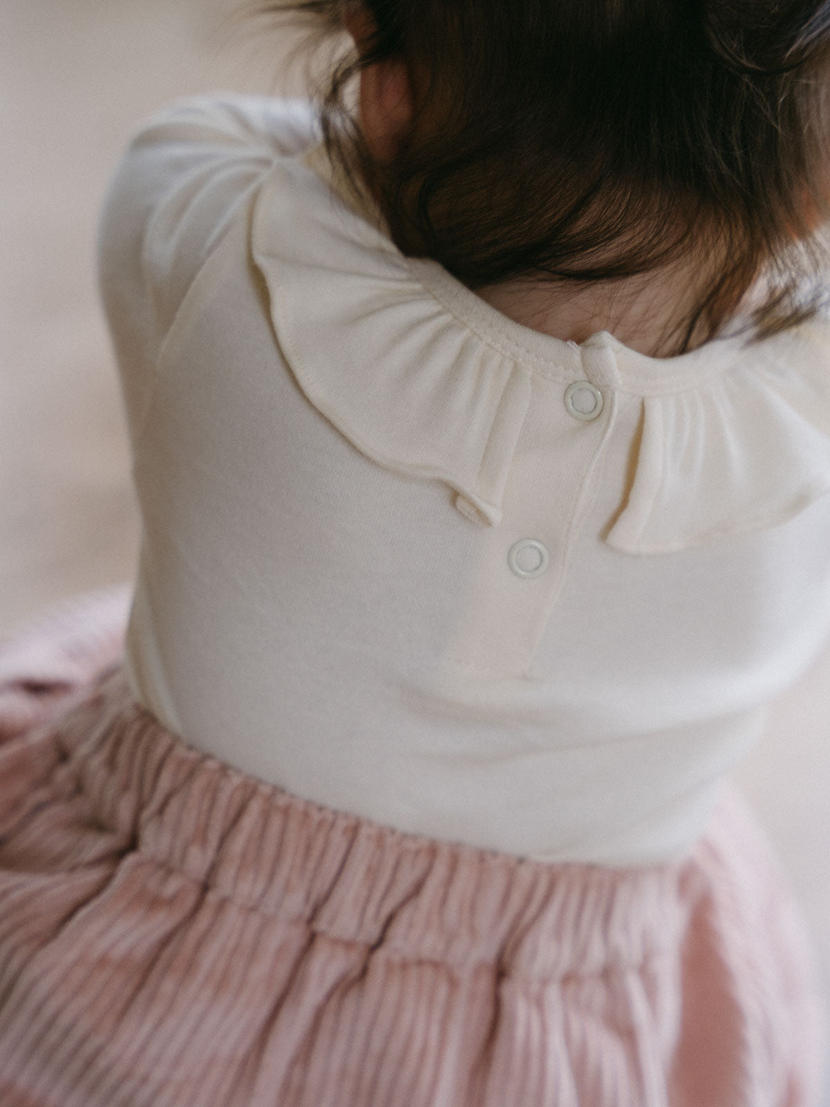 Child wearing cream long sleeve bodysuit with ruffle collar and pink pants Ruffle Long Sleeve Bodysuit - Ecru Baby girl
