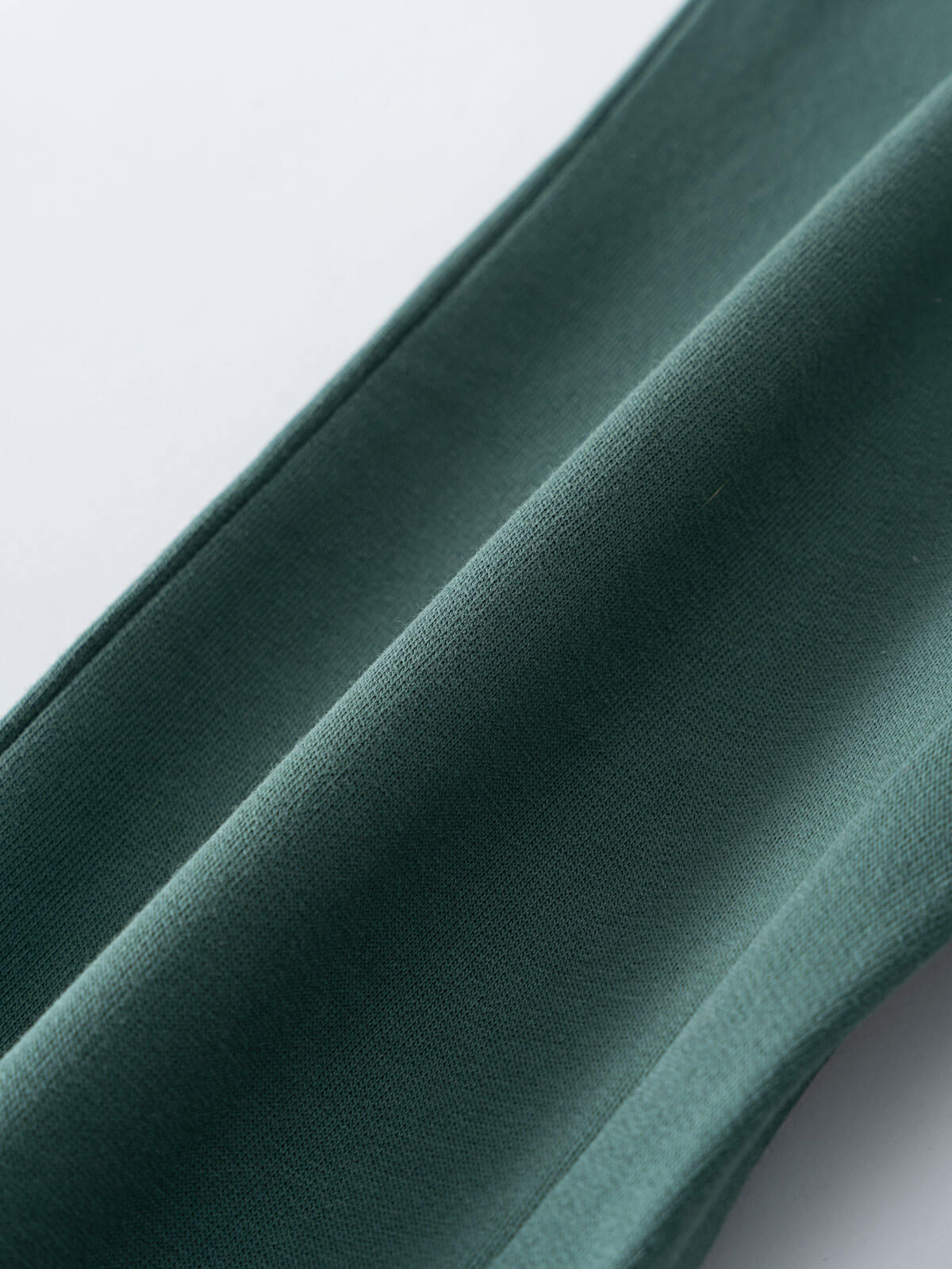 Close-up of folded green fabric showing texture and seams Sweatpants - Balsam Boys