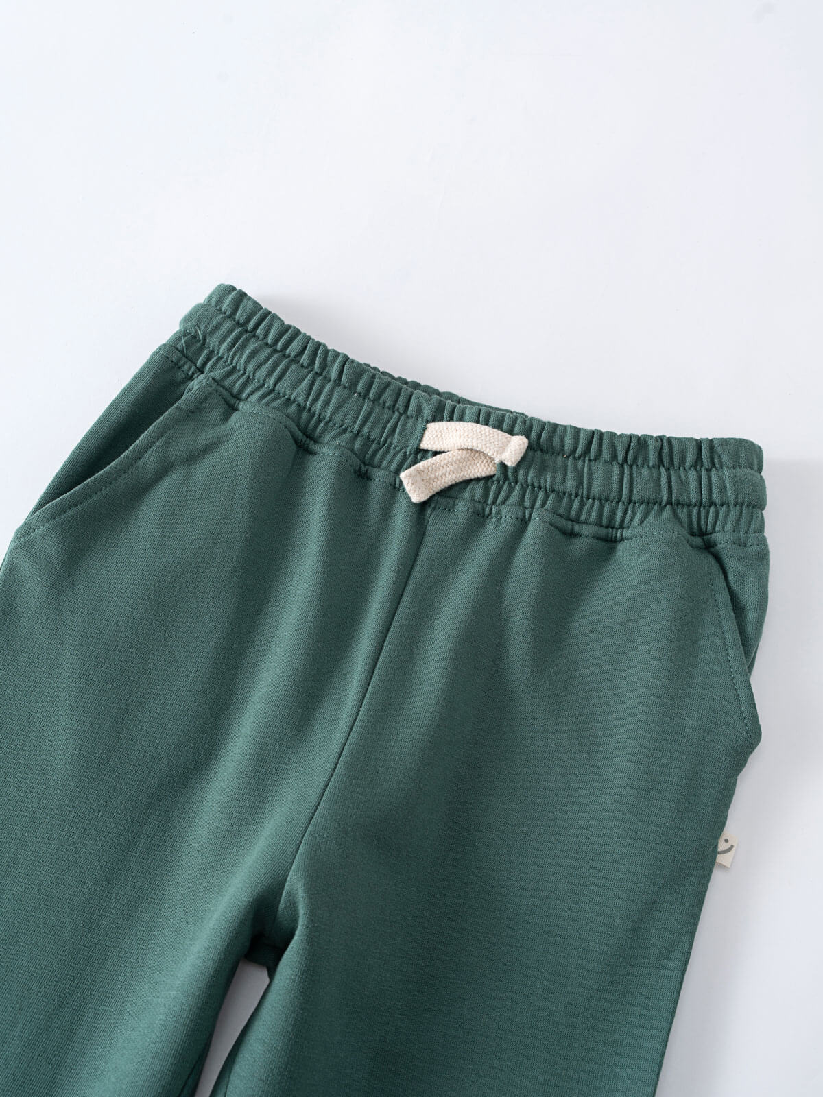 Close-up of green sweatpants with elastic waistband and cream drawstring Sweatpants - Balsam Boys