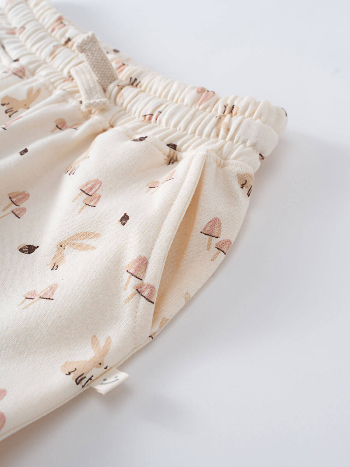 Close-up of cream elastic waistband with mushroom and bunny print pattern Sweatpants - Forest Gathering Ecru Girls