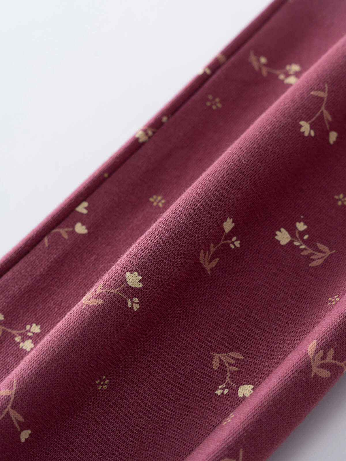 Close-up of burgundy fabric with small floral print pattern Sweatpants - Wild Meadow Plum Jam Girls