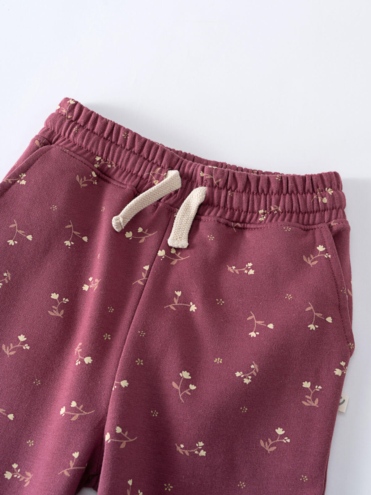 Close-up of burgundy sweatpants with cream floral print and drawstring waistband Sweatpants - Wild Meadow Plum Jam Girls