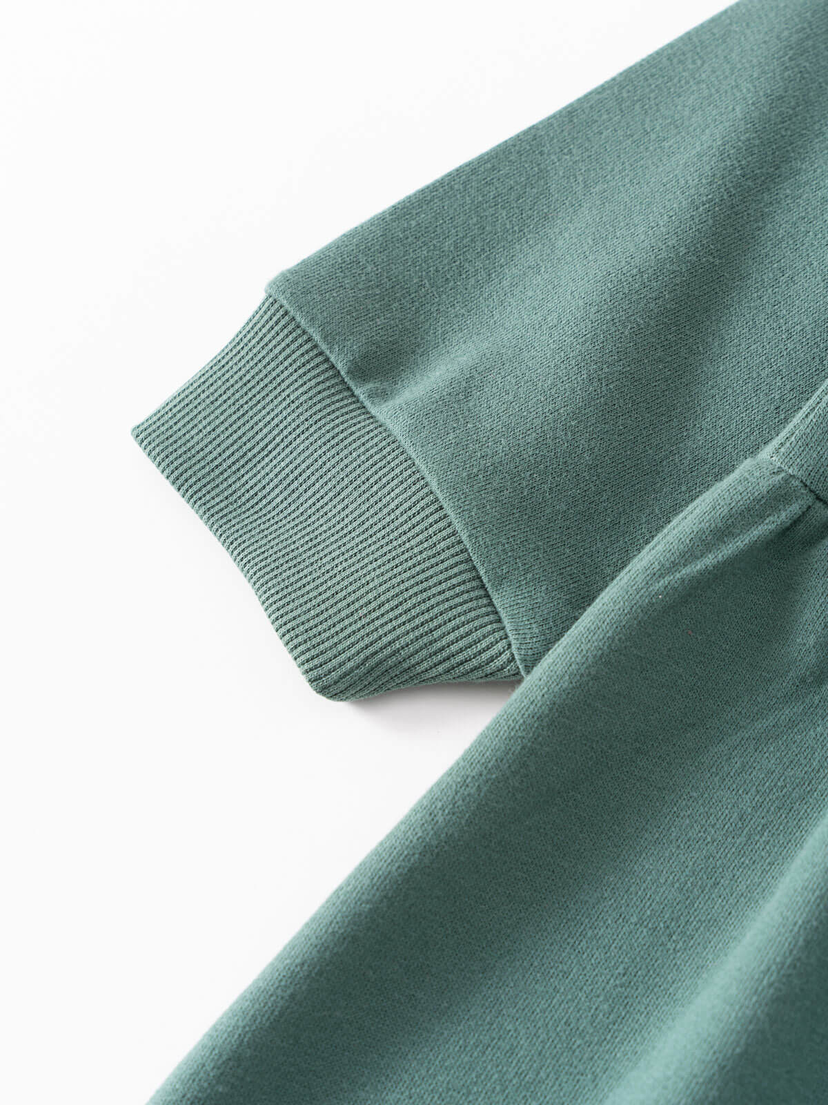 Close-up of sage green knit fabric showing ribbed cuff detail Sweatshirt Dress - Dove Girls