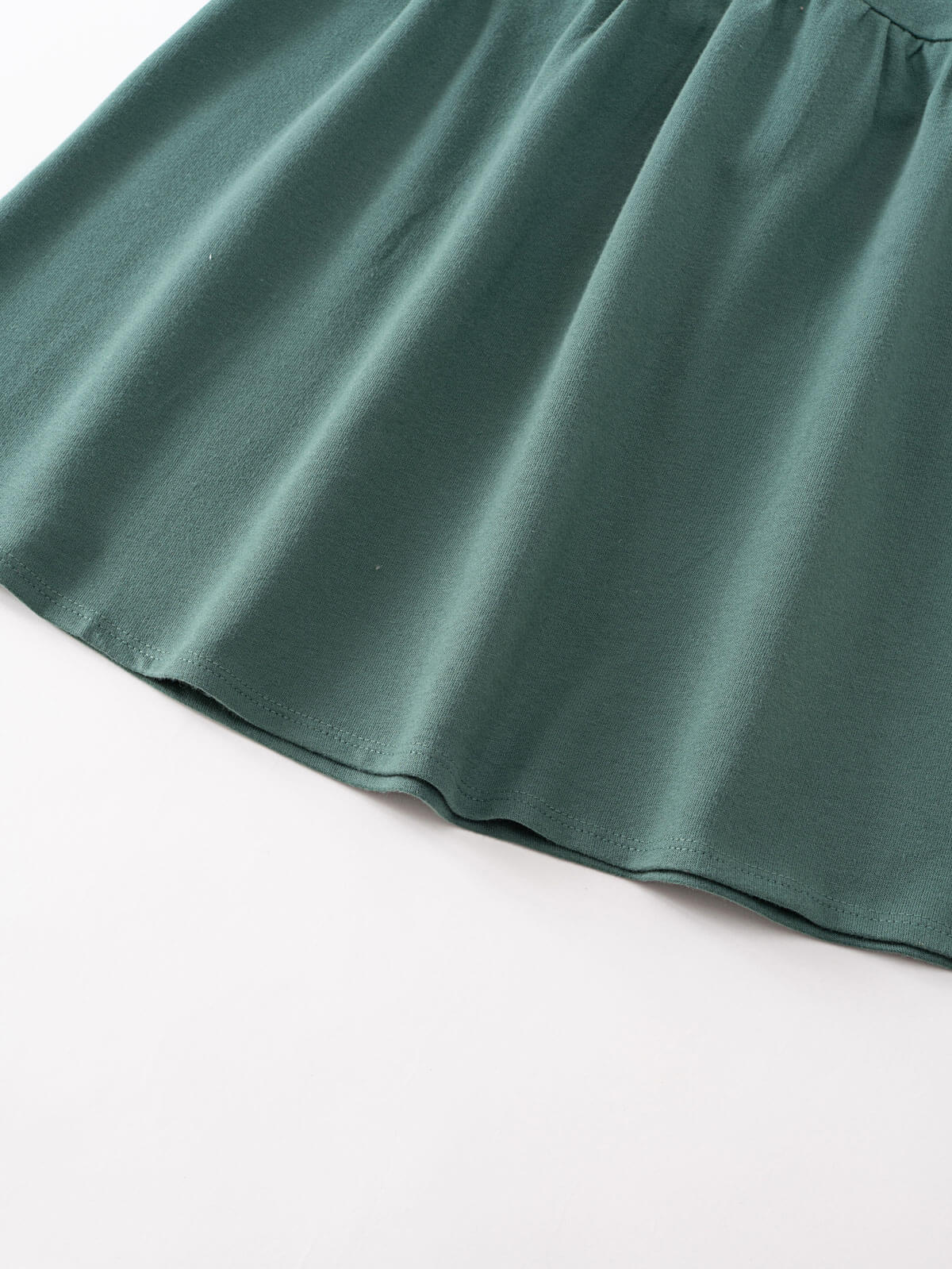 Close-up of dark green fabric with soft draping and hemline detail Sweatshirt Dress - Dove Girls
