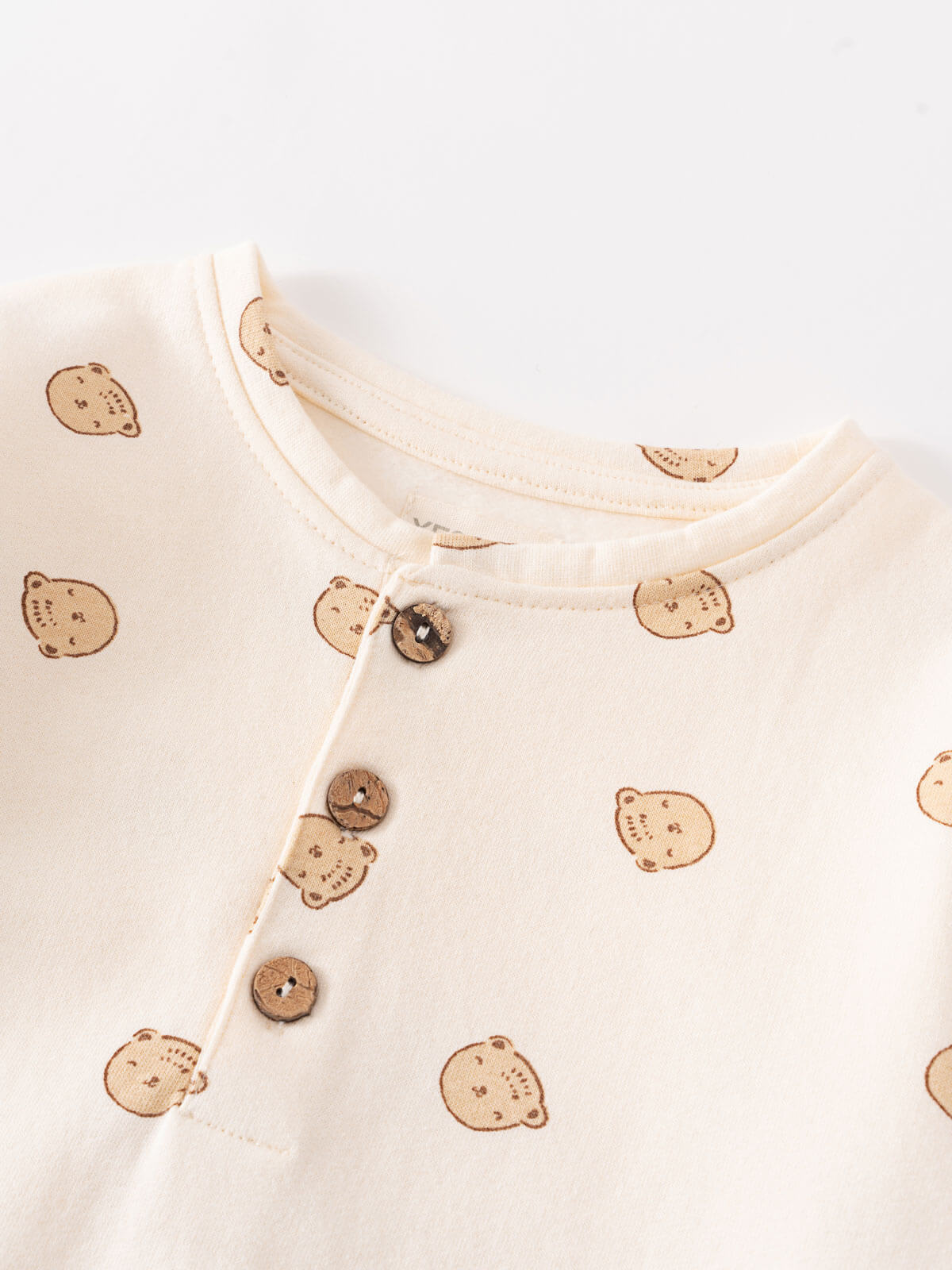 Close-up of cream onesie with brown bear print and coconut buttons Sweatshirt Onesie - Cosy Bear Ecru Baby boy
