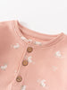 Close-up of pink fabric with white rabbit print and brown buttons Sweatshirt Onesie - Meadow Friends Blush Baby girl