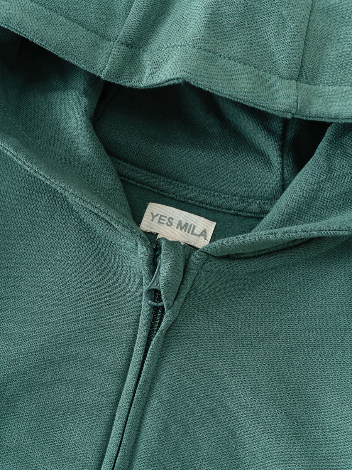Close-up of a teal green zip hoodie with YES MILA label visible Zip Hoodie - Balsam Boys