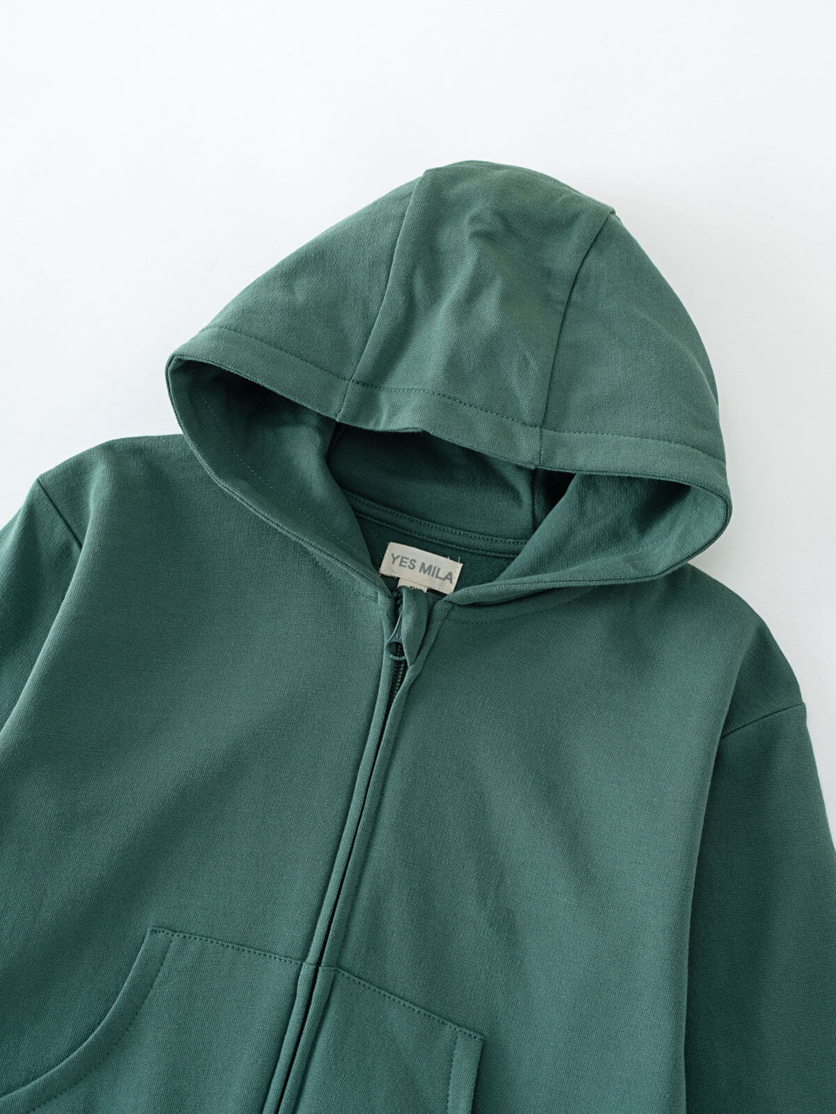 Close-up of a dark green hooded sweatshirt with zipper and front pocket Zip Hoodie - Balsam Boys