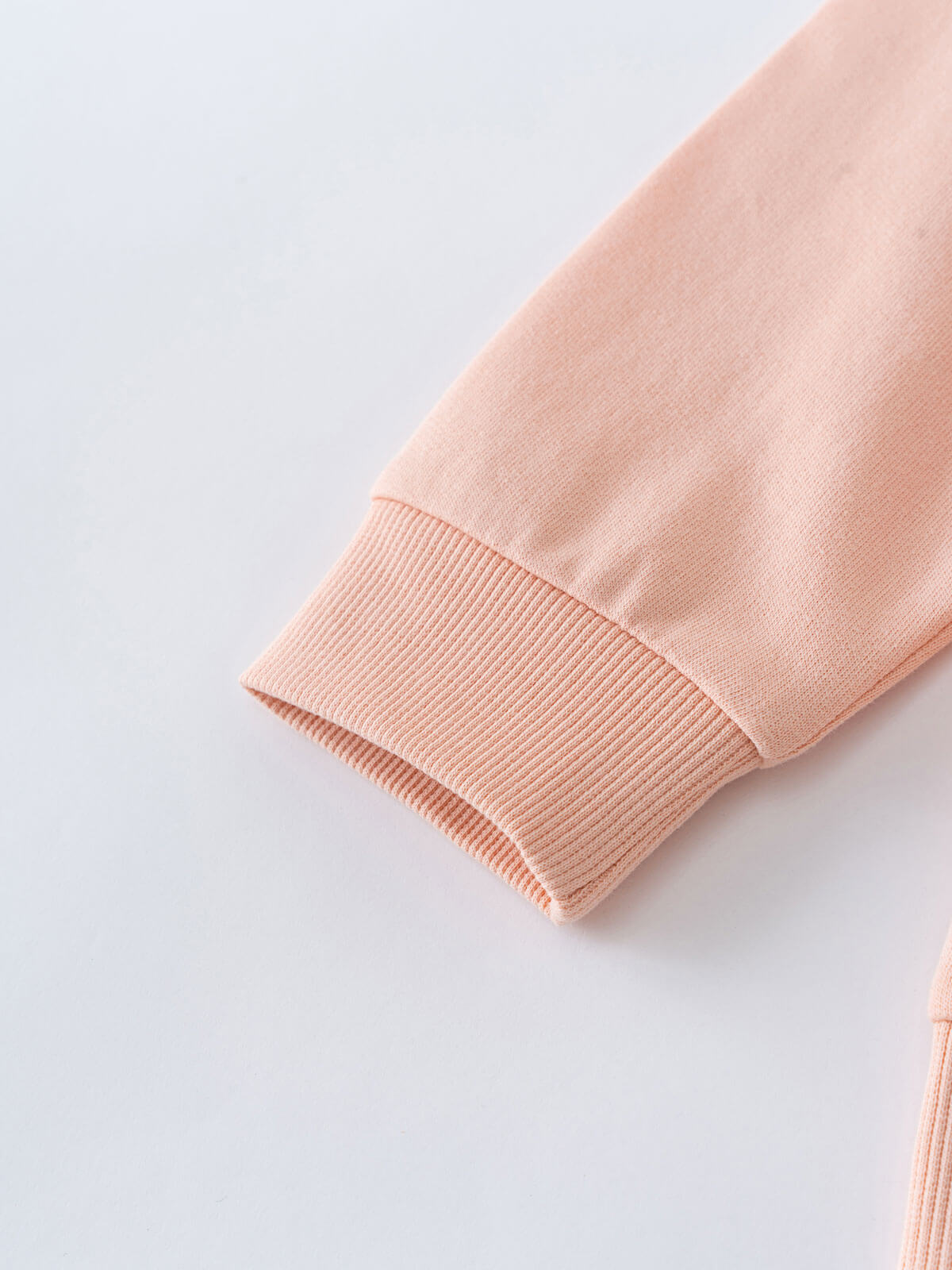 Close-up of a peach-colored sleeve with ribbed cuff detail Zip Hoodie - Mallow Boys