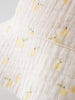 Close-up of white textured fabric with yellow lemon and green leaf pattern Baby Bucket Hat - Lemons Baby girl