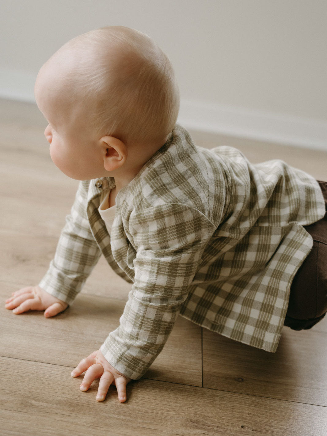Baby crawling on wooden floor wearing olive and cream checkered shirt Baby Check Shirt - Woven Check Baby boy