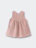Pink corduroy dress with pockets on a light gray background