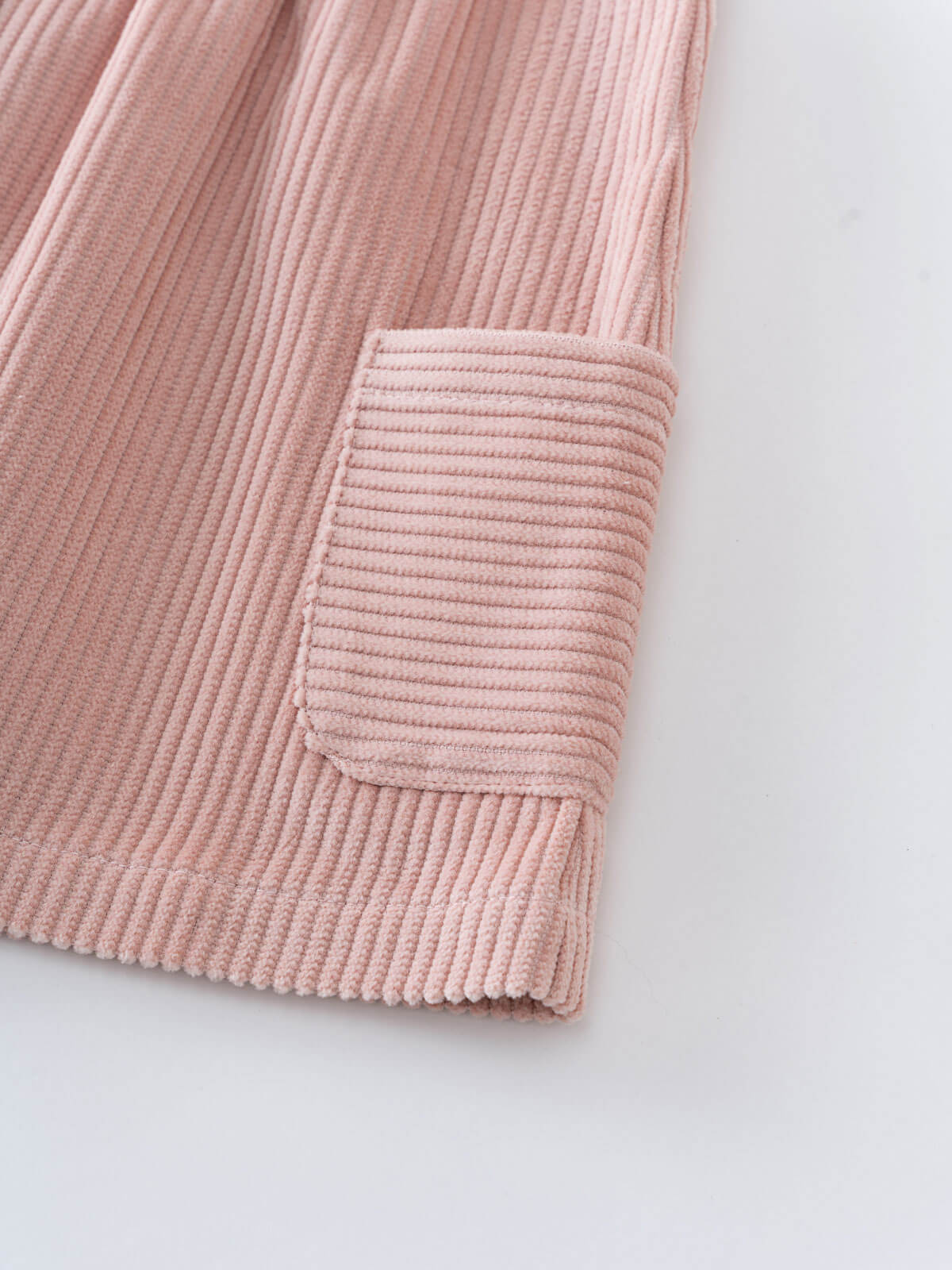 Pink corduroy dress with a pocket on a white background