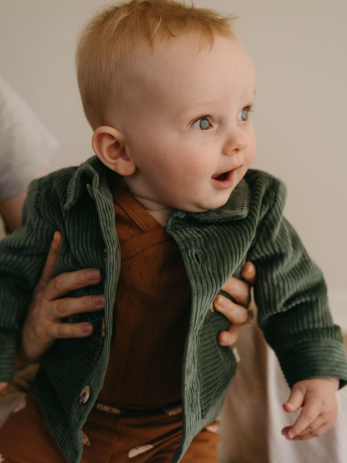 Baby wearing a green corduroy jacket with a blurred background Baby Corduroy Jacket - Balsam Baby boy