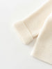Knitted cream-colored cardigan on a white background