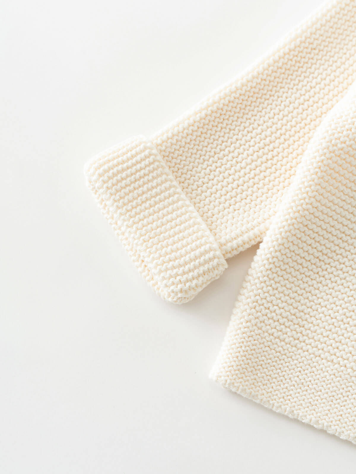 Knitted cream-colored cardigan on a white background