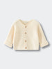 Beige baby knitted cotton cardigan on a light gray background