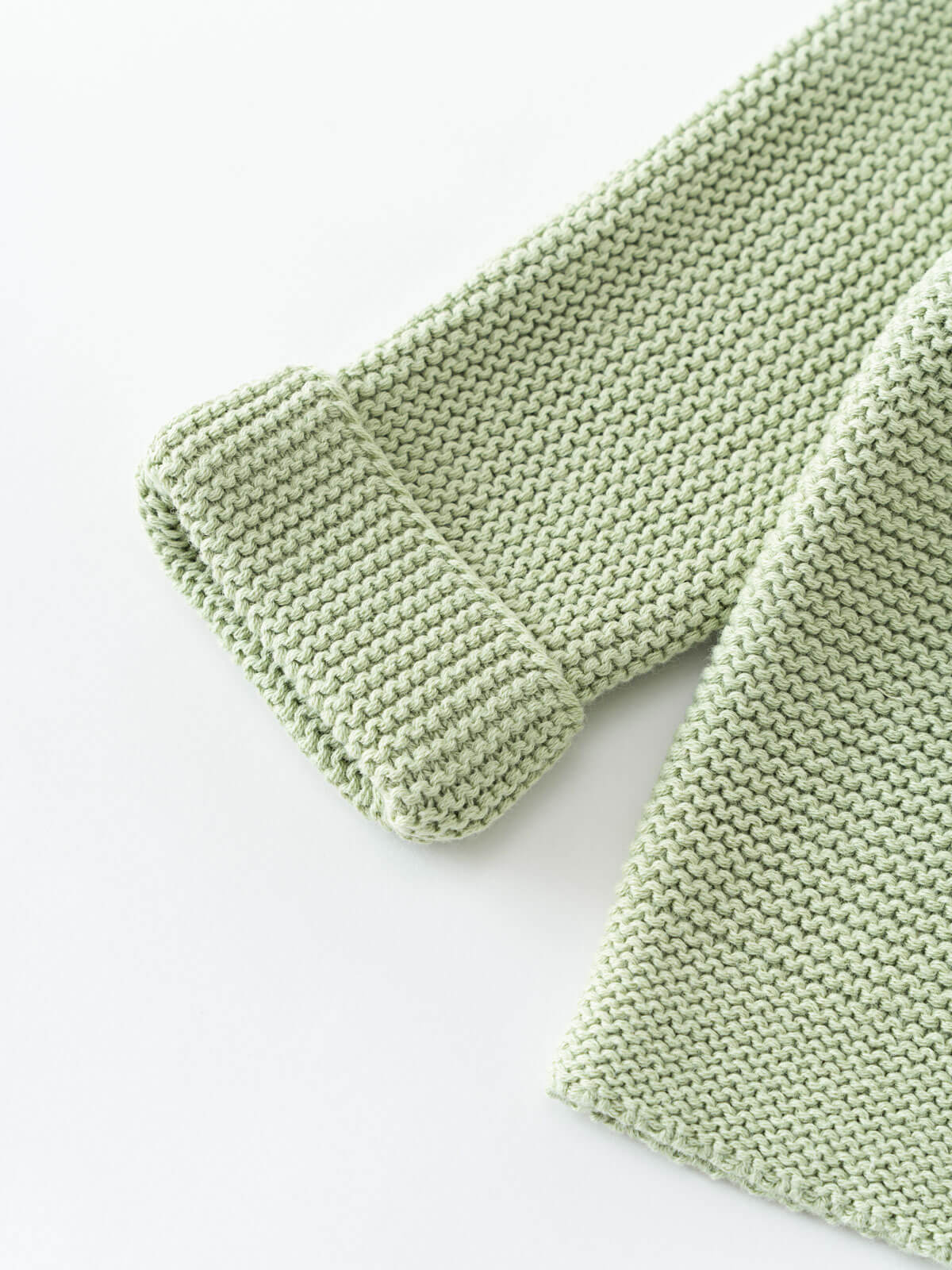 Green knitted cotton cardigan on a white background
