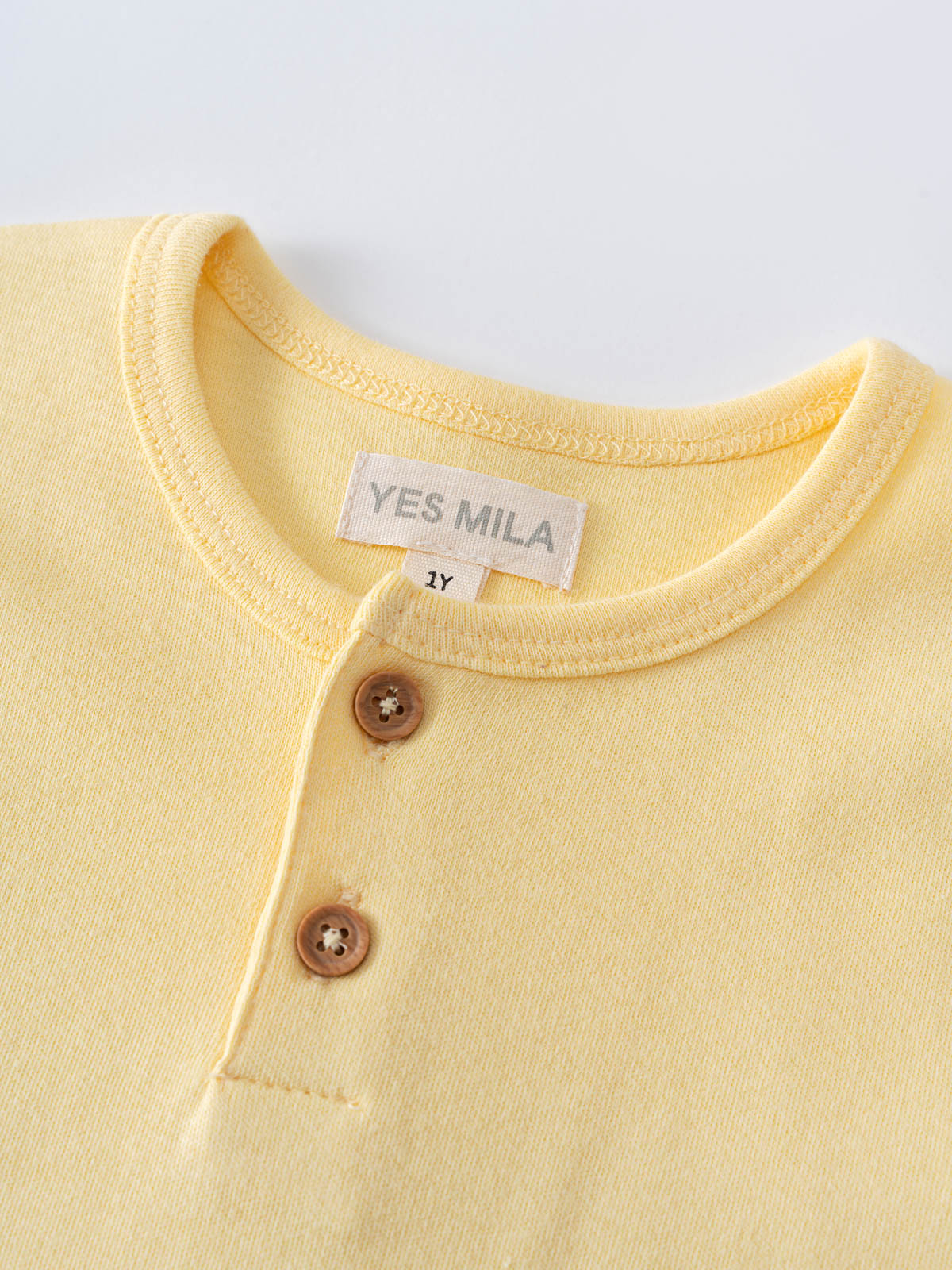Close-up of a pale yellow henley shirt with brown buttons Baby Henley Tee - Sun Soaked Baby boy