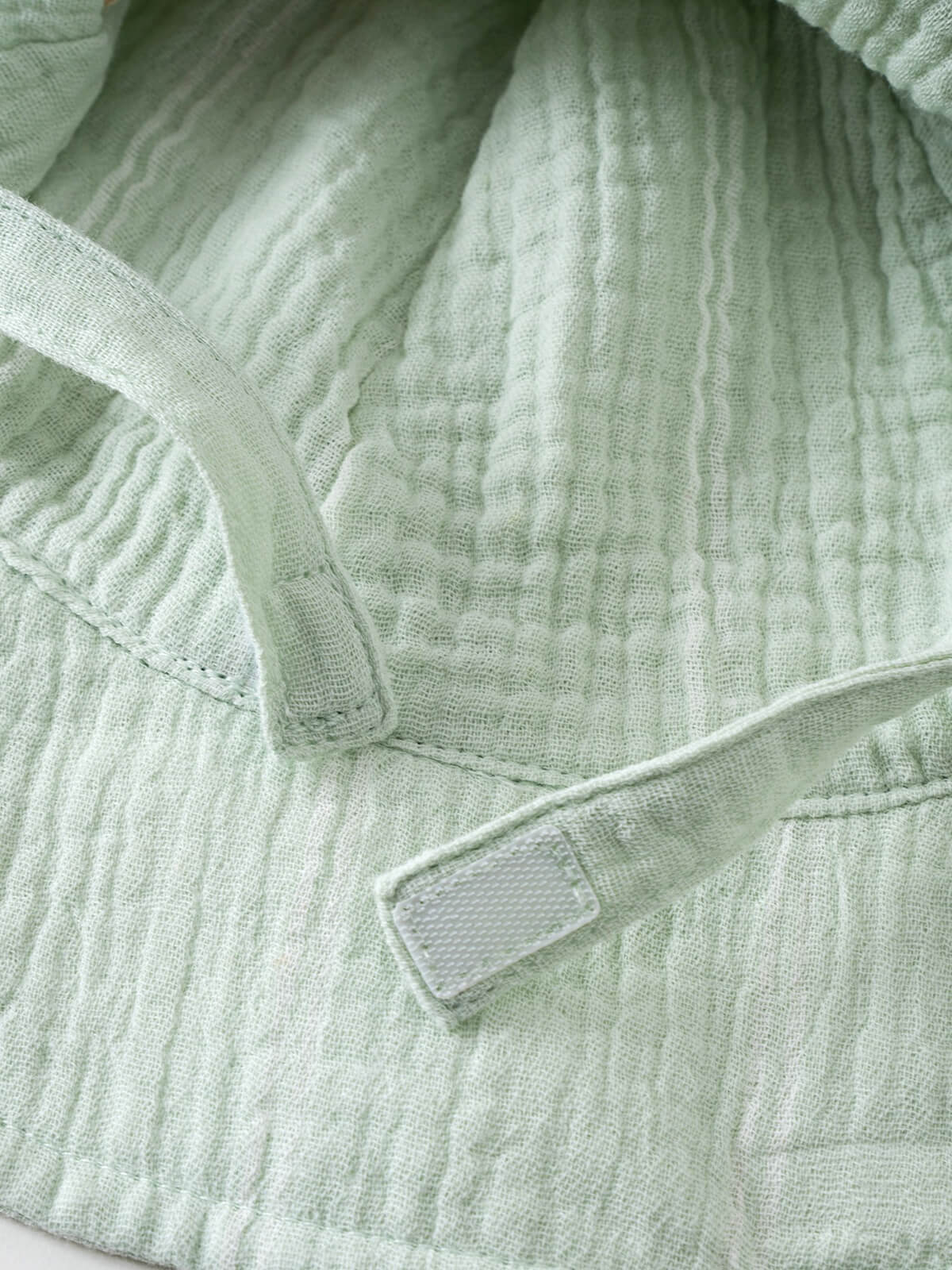 Close-up of a pale green striped fabric sun hat with adjustable straps Baby Muslin Sun Hat - Green Stripe Baby boy