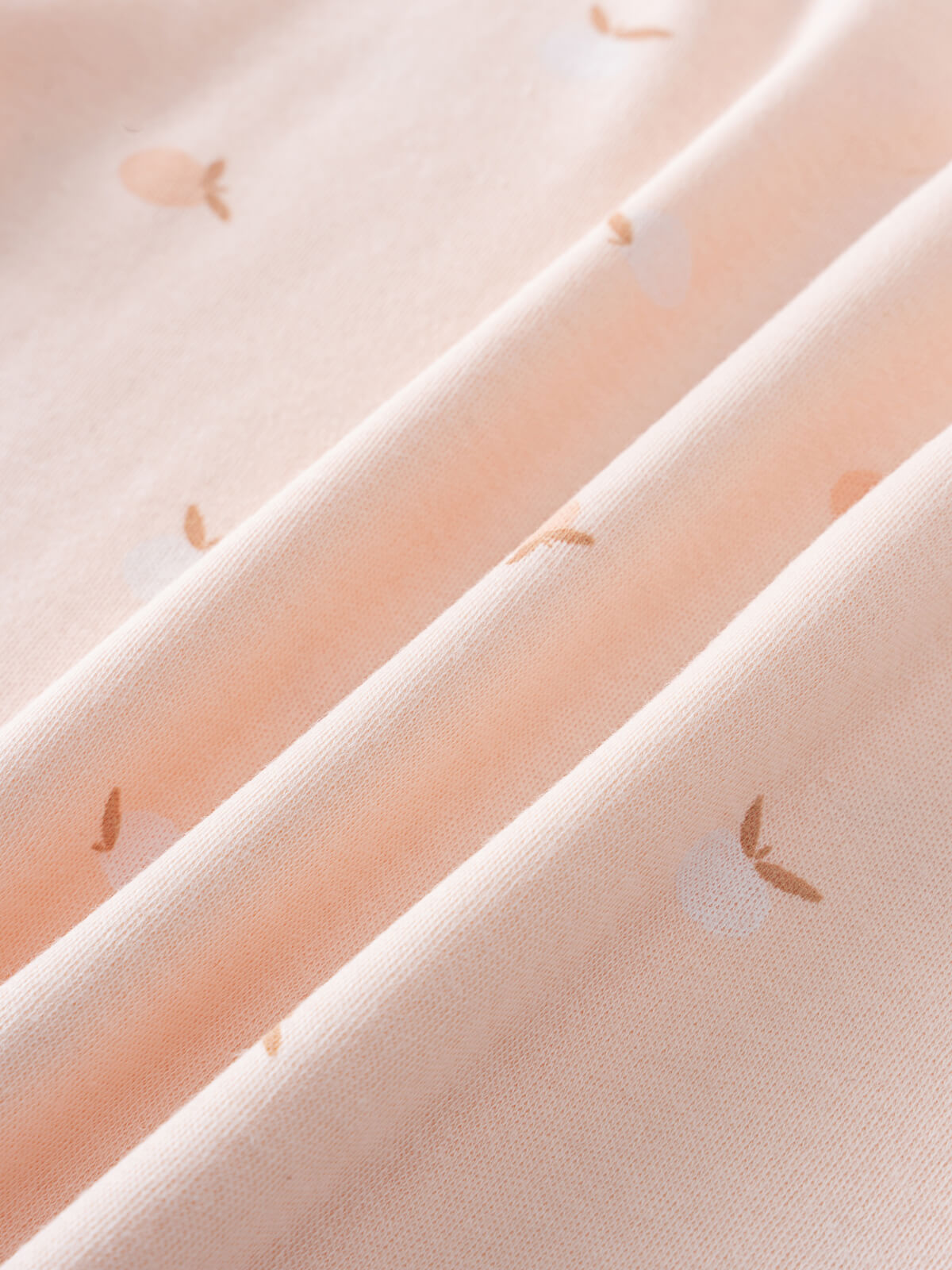 Close-up of peach fabric with small apple print pattern Baby Printed Short Sleeve Tee- Apples Baby girl
