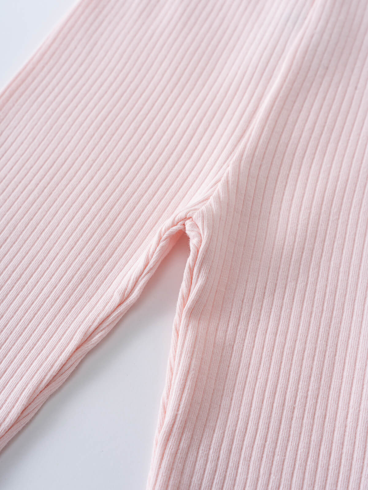 Close-up of pale pink ribbed fabric showing textured detail and sleeve Baby Ribbed Leggings - Candy Floss Baby girl