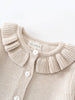 Beige knitted cardigan with ruffled collar and visible brand label on a light background Baby Ruffle Cardigan - Ecru Baby girl