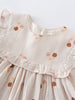 Close-up of a baby dress with floral embroidery on a white background
