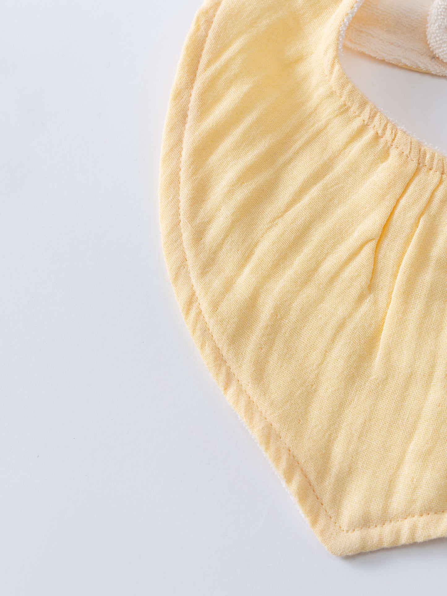 Close-up of a pale yellow fabric bib with gathered elastic edging Bandana Bibs 3 Pack - Lemons Baby girl
