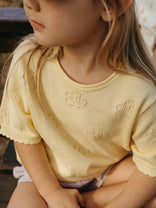 Child wearing a yellow knit sweater with intricate patterns