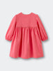 Coral pink dress with long sleeves on a light gray background