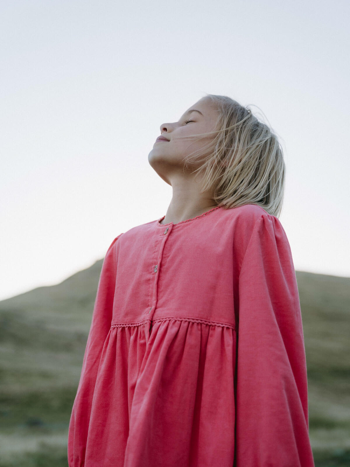 Girl wearing a pink shirt with a blurred natural background