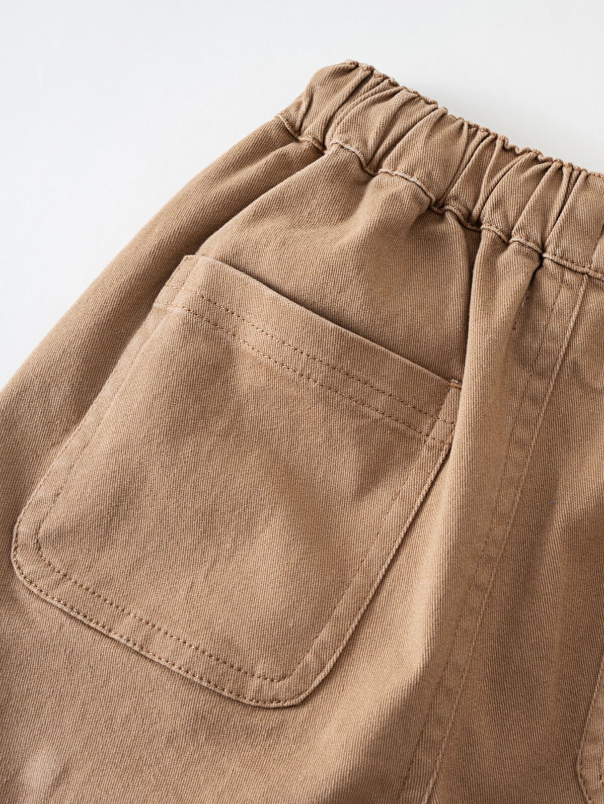 Close-up of beige shorts showing elastic waistband and rounded pocket detail Cargo Shorts - Biscuit Boys