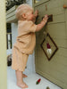 Child playing with a wooden playhouse door
