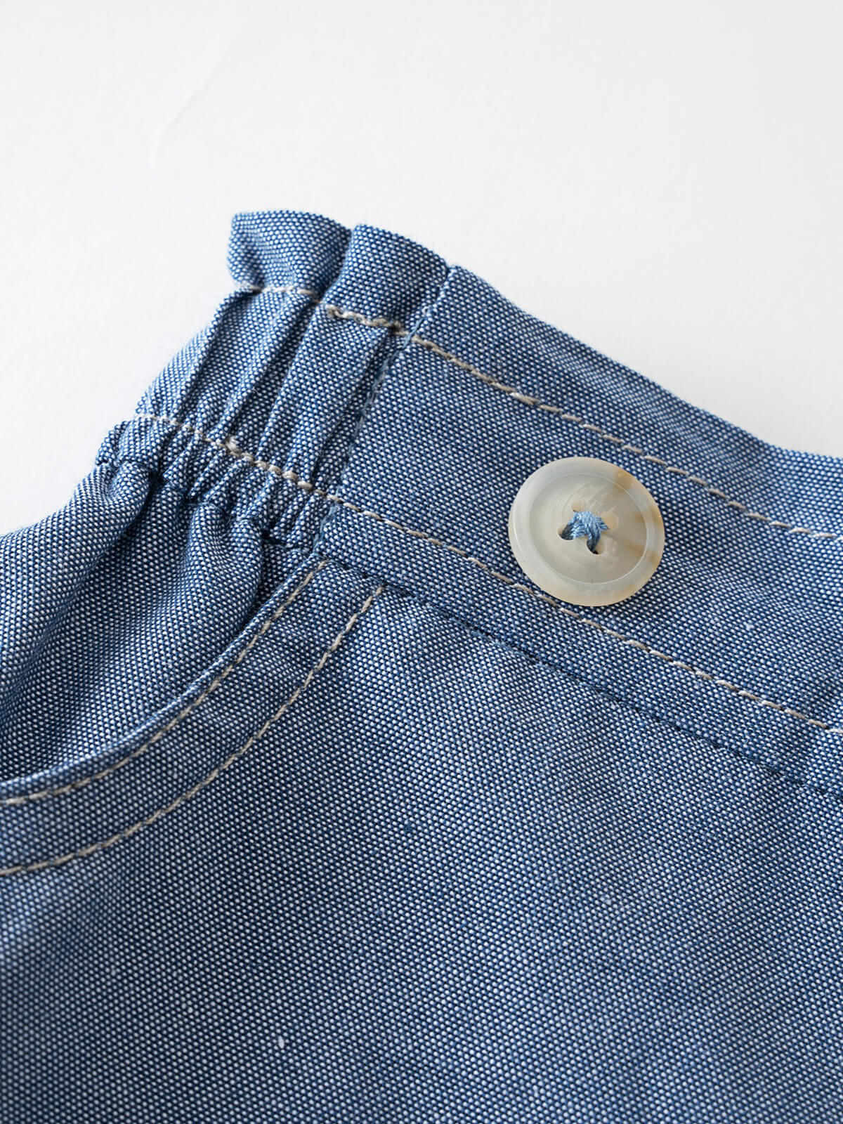 Close-up of blue chambray shorts with elastic waistband and button detail Chambray Shorts - Blue Chambray Girls