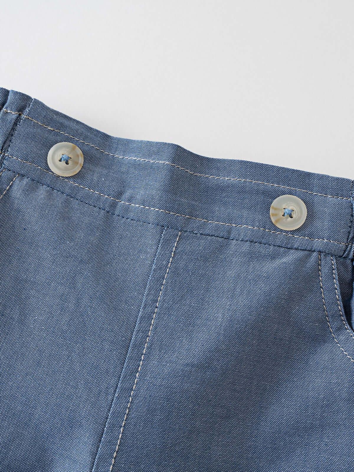 Close-up of blue chambray shorts with white buttons and stitching detail Chambray Shorts - Blue Chambray Girls