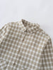 Plaid shirt with brown and white pattern on a light gray background