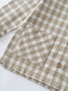 Close-up of a brown and white shirt fabric with a pocket and button on a white background