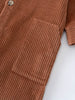 Close-up of rust-colored corduroy fabric with button and chest pocket detail Corduroy Jumpsuit - Russet Baby boy