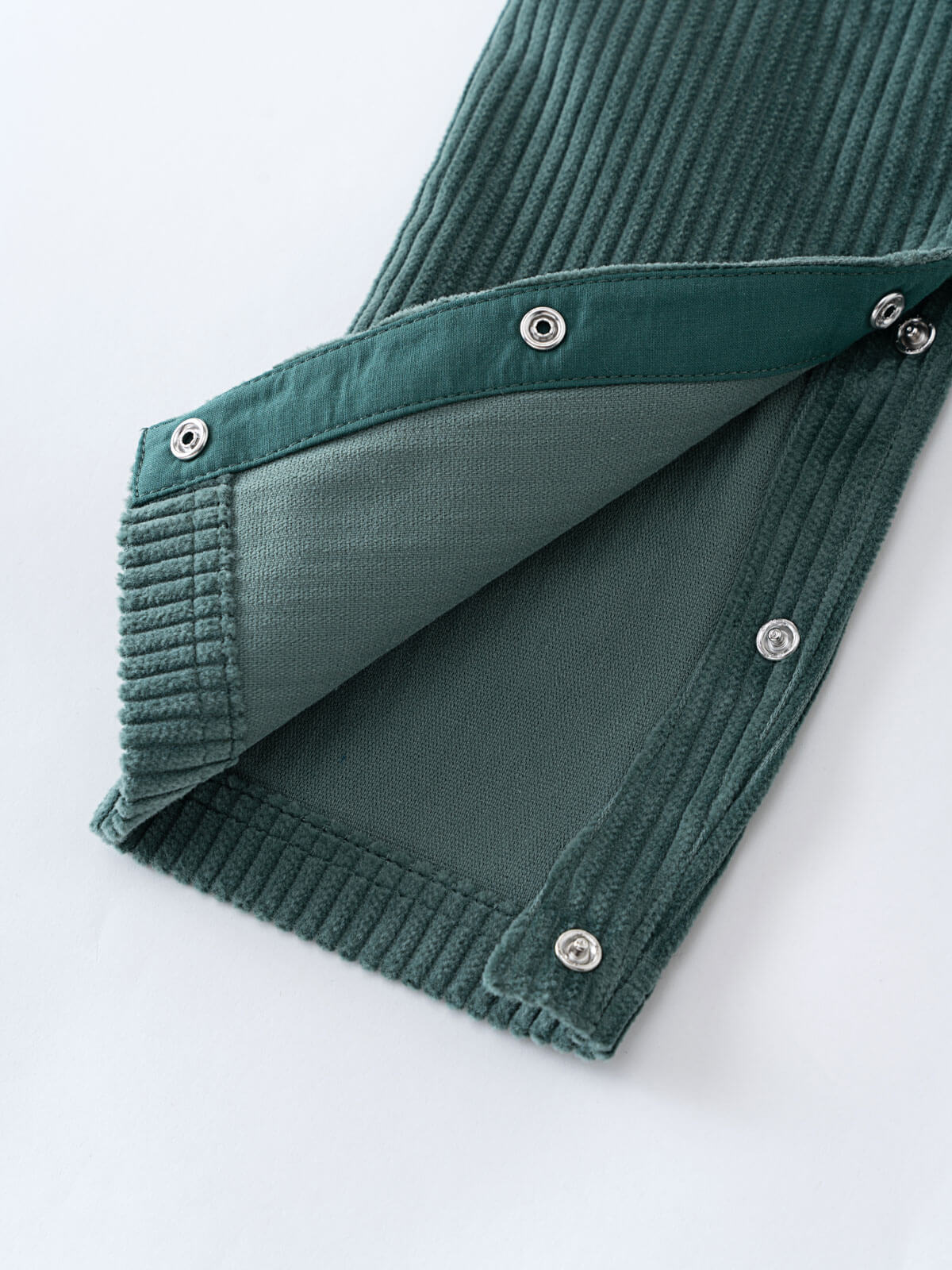 Green corduroy overalls  with button details on a white background