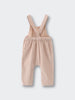 Beige corduroy overalls on a light gray background